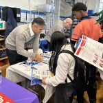 Bringing Futures into Focus Program rep speaking with student at Manhattan Comprehensive's College & Career Fair
